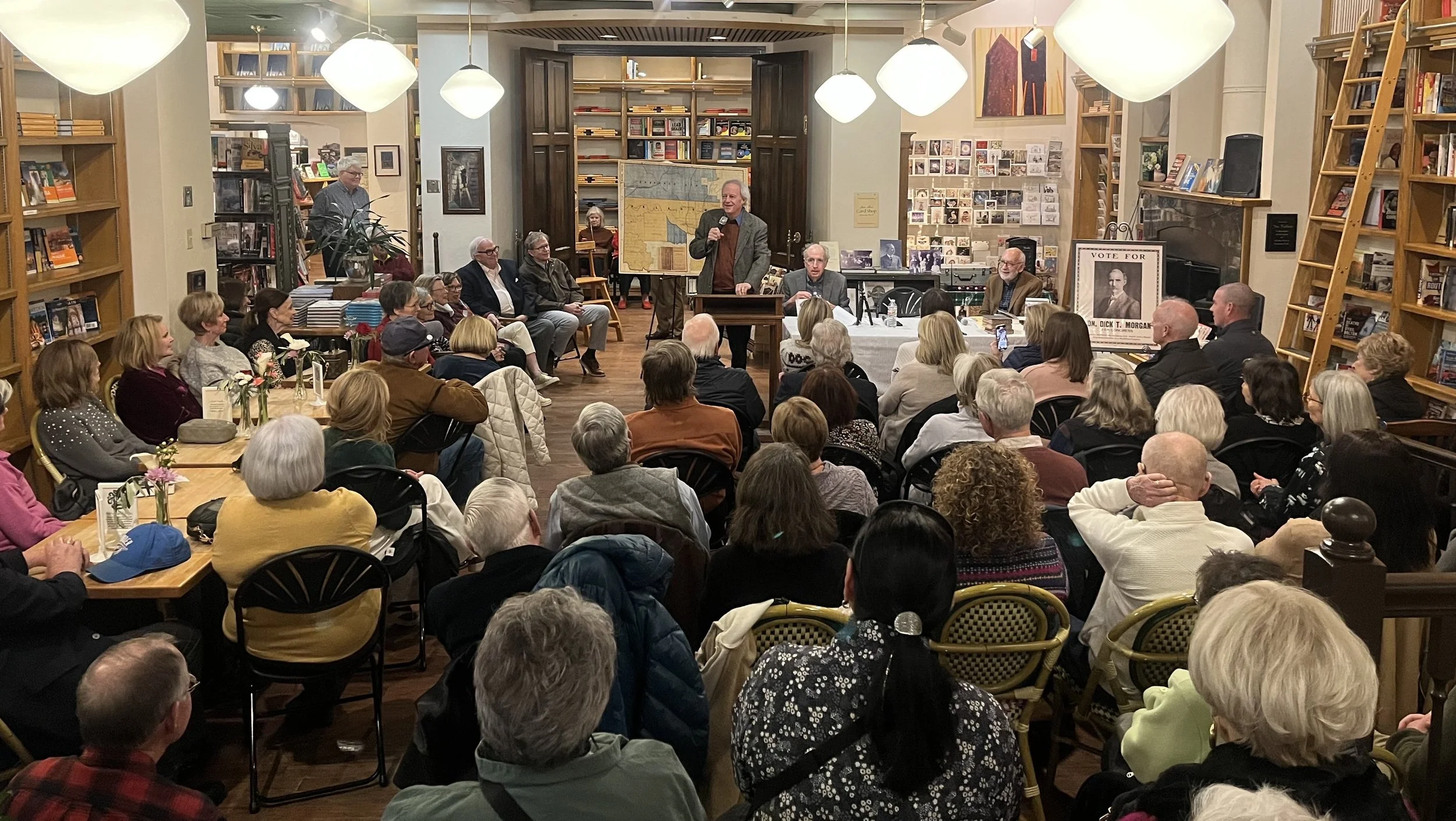 A packed crowd of attendees inside a bookstore listening to Michael J. Hightower speak at a book event on February 17, 2025