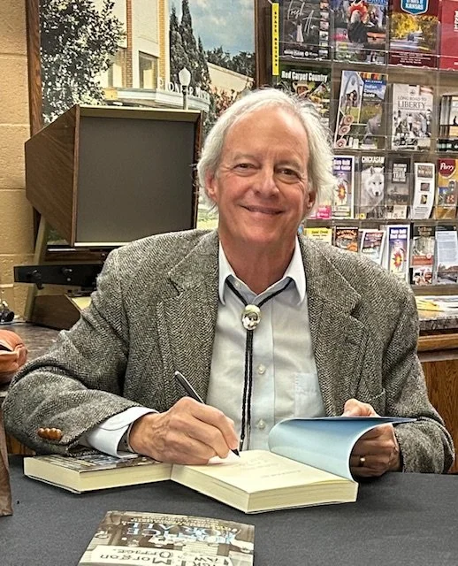 Michael J. Hightower signing copies of Justice for All at a table during an event at the Plains Indians & Pioneers Museum in Woodward, Oklahoma, on February 15, 2025