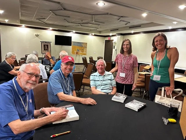 Michael J. Hightower and attendees gathered around a table at the Morgan Family Reunion in Granbury, Texas, May 2025, with copies of his book on the table